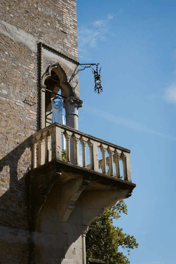 The wedding dress hanging from the Gothic balcony of the tower