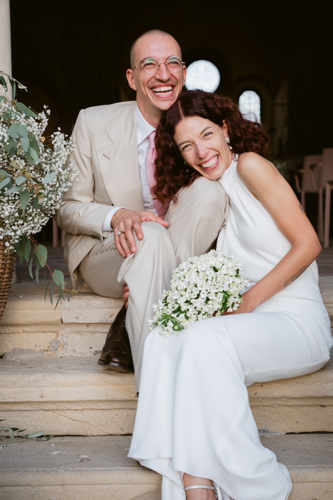 The newlyweds laughing on the stone steps